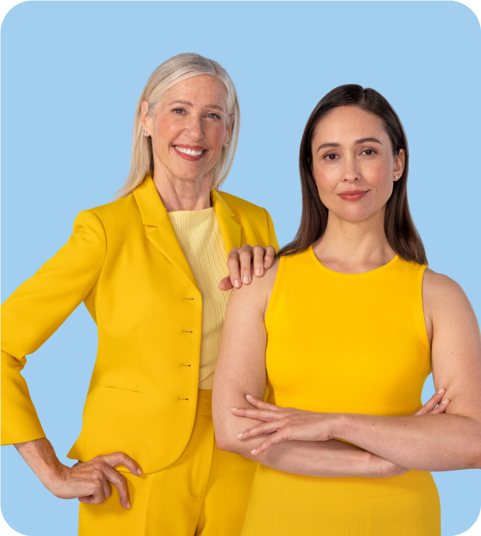 Two women one older one younger standing side by side, one has their hand on the others shoulder