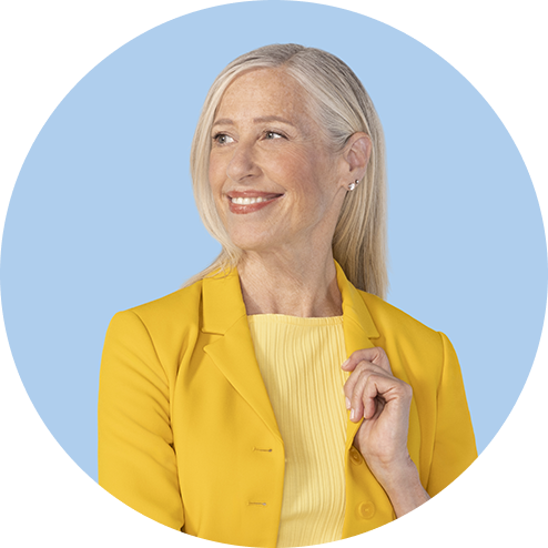 A woman smiling looking to the side with a play button in the top right corner