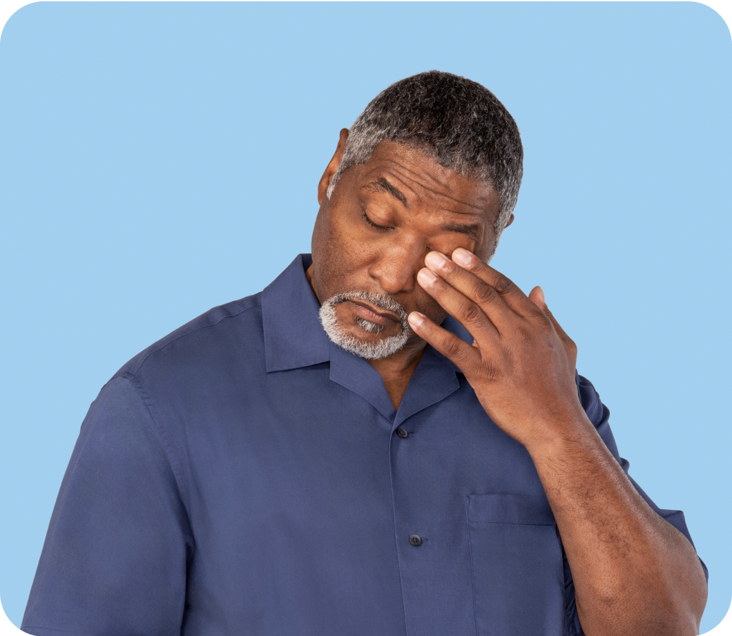 Man in a blue shirt rubs his itchy eyes